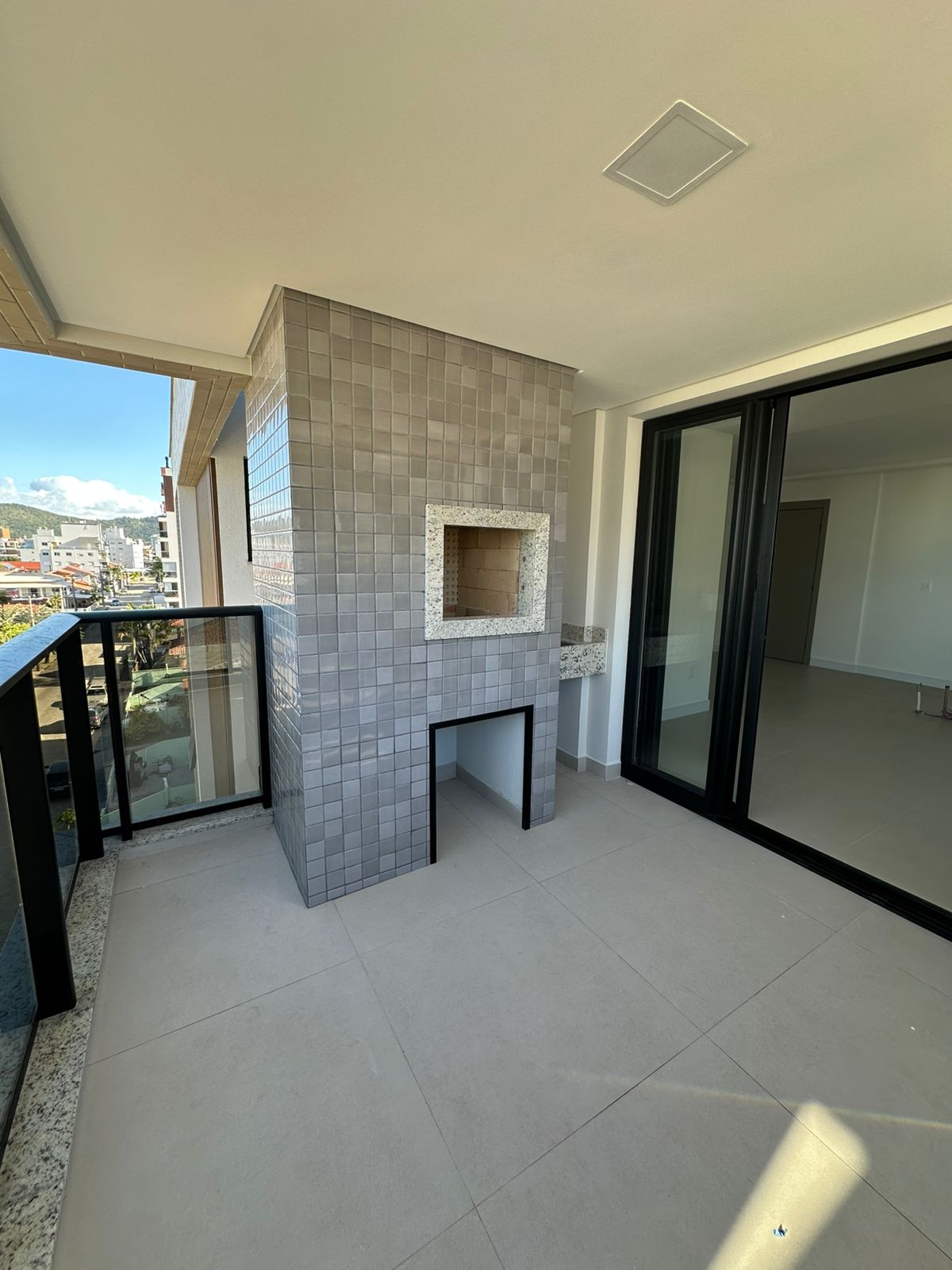 Balcony with tile-clad charcoal barbecue and access to the living room